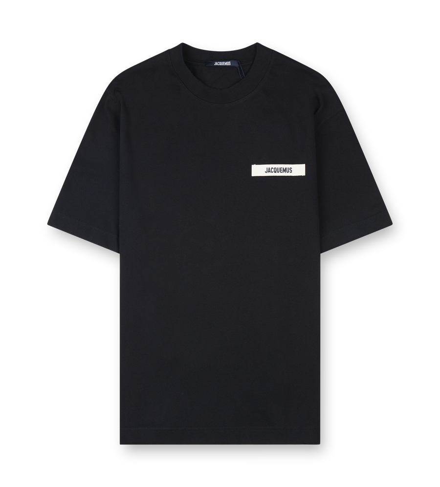 Black t-shirt with a small white logo on a white background