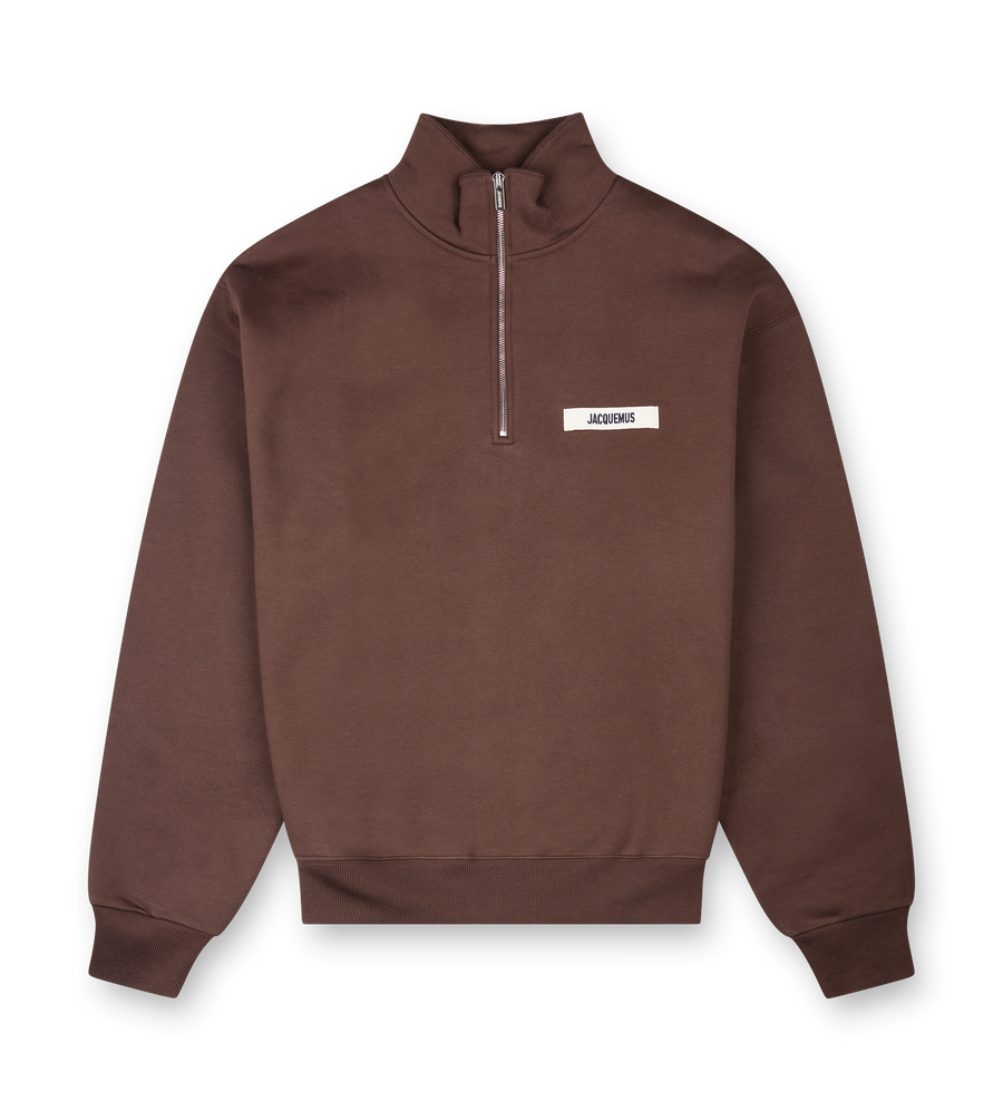 Bruin sweatshirt met halve rits en merklogo op een witte achtergrond