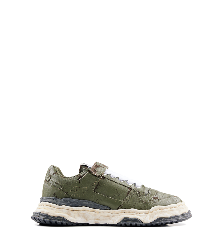 Green sneaker with a white sole on a white background