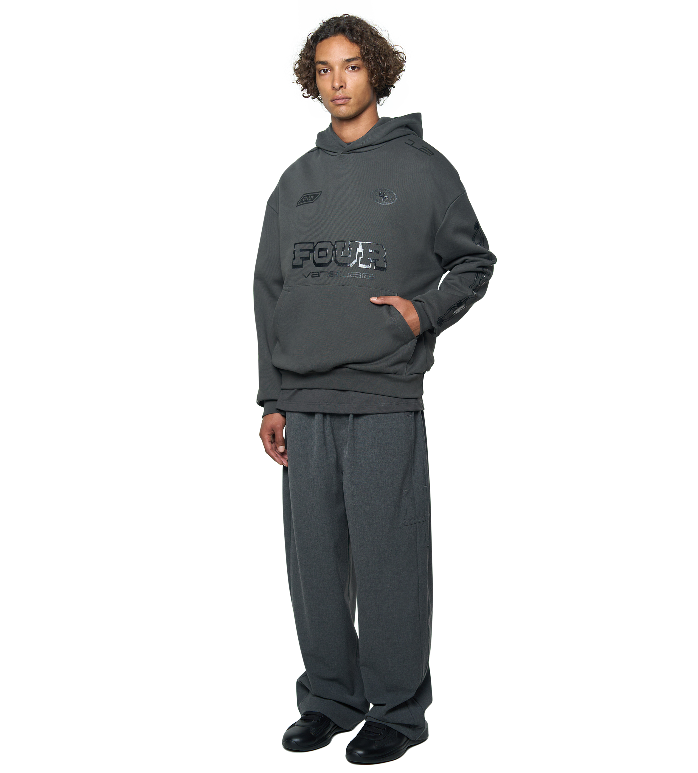 Person wearing a gray hoodie and pants with a brand logo on a white background