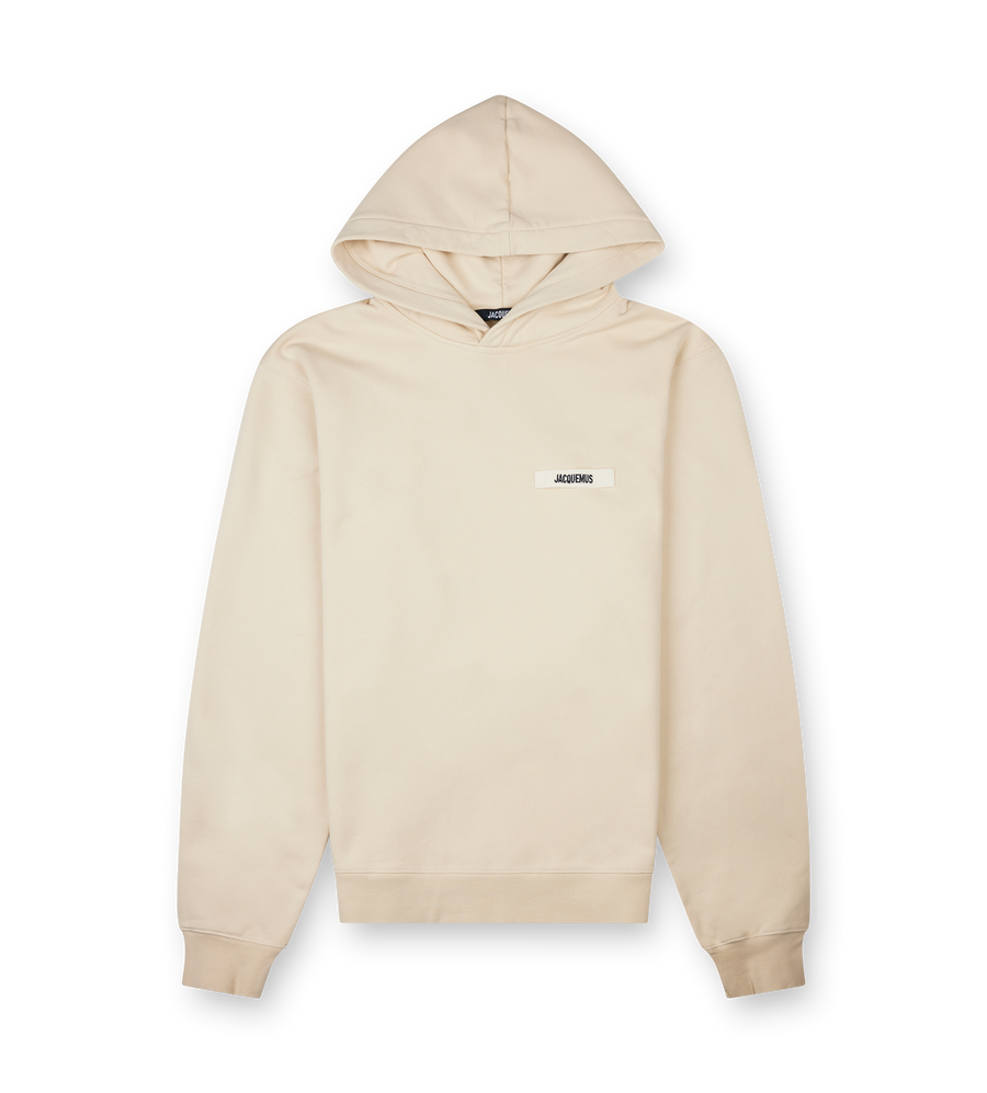 Beige hoodie with a small logo on a white background