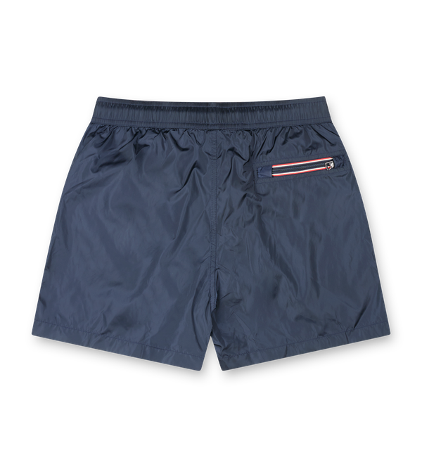 Moncler navy nylon swim shorts with drawstring waist, side pockets, zipped back pocket and silicone logo patch